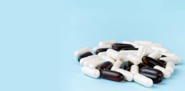 İlaç hapları ve vitaminler. Mavi yüzeyde ilaç ya da takviye kapsülleri. Probiyotik, inulin, glukozamin yığını.