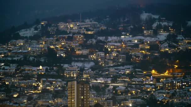 Abend-Nacht-Zeitraffer einer kleinen Stadt, die auf Bergen liegt. Europäische Stadt oder Dorf vom höchsten Aussichtspunkt nach Sonnenuntergang. — Stockvideo