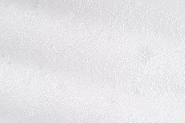 White foamy cleansing skin care product texture from soap, detergent, shampoo, shaving foam or cleanser. Soapy surface closeup. Foam macro background with bubbles. Beer drink backdrop — Stock Photo, Image