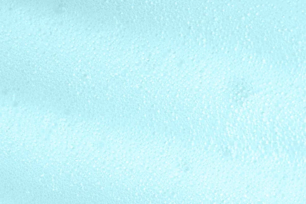 Blue soapy surface closeup. Foamy cleansing skin care product texture from soap, detergent, shampoo, shaving foam. Foam macro background with bubbles. Laundry spume — Stock Photo, Image