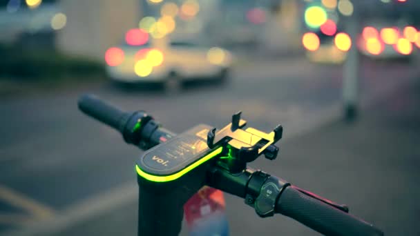 Pontapé elétrico scooter close-up em ambiente urbano à noite contra o fundo da cidade turva, aluguel de scooter, liberdade de movimento. Bicicleta elétrica na cidade. — Vídeo de Stock