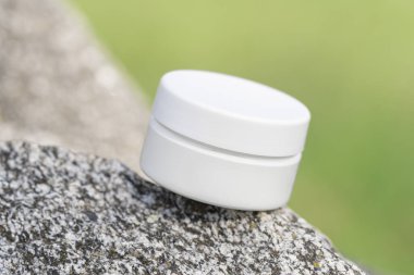 Taş doğal arka planda güzellik ürünleri ambalajı. Kavanozda organik kozmetik. Cilt kremi için losyon, el kremi ya da göz kremi. Ön manzara, yakın çekim. Reklam için kozmetik modelleri.