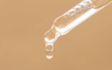 Gerekli yağlı boru, peptitli serum, emülsiyon, bej arka planda hyaluronik asit. Bej damlatıcının yakın çekimi, düşen yağ damlası. Güzellik ürünleri..