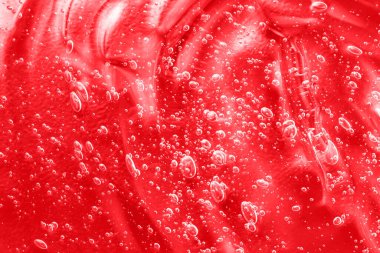 Kırmızı nemlendirici sürme. Serum sıvısı kozmetik ürünleri, jöle kozmetik ürünleri. Hyaluronik asit toner örneği. Kolajen ve vitaminli şeffaf krem örneği lekesi. Baloncuklu jel dokusu. Yakın çekim.