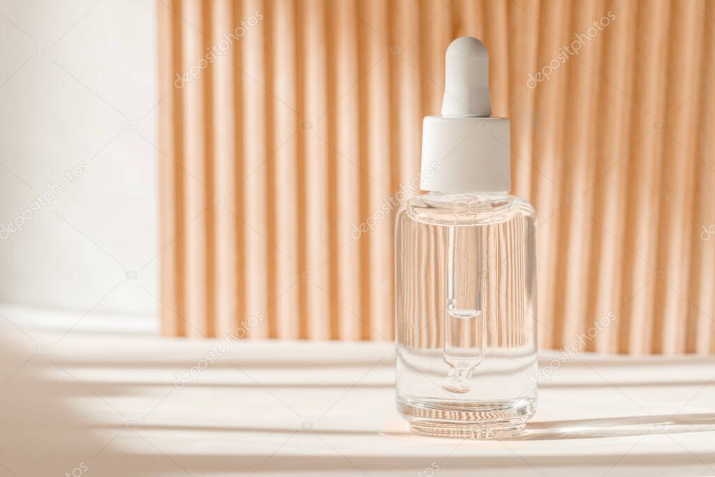 Serum cosmetic bottle, hyaluronic acid on brown background. Serum product with peptide and collagen cosmetics. Cosmetic showcase, art deco, natural shadows. Commercial, modern brand packaging