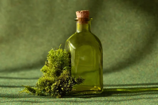 Botella de aceite esencial natural sobre fondo de hierbas verdes — Foto de Stock