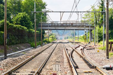 Yeşil doğal manzaralı bir tren istasyonu. Demiryolu ile endüstri sahnesi. Demiryolu kavşağı, platform. Ulaşım