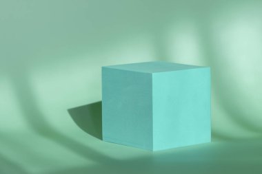 Doğal oda gölgeleriyle damgalamak ve paketlemek için minimalist mavi kübik kaide. Kozmetik ürün sunumu için Geometrik Podyum.