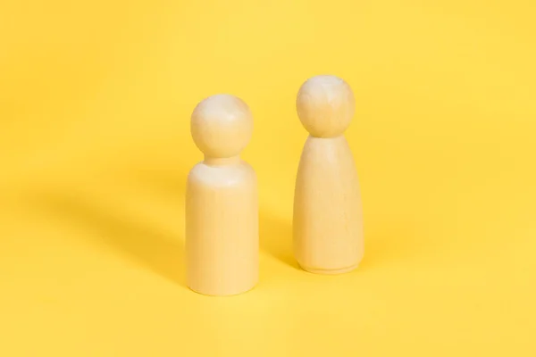 Figuras de madera de hombre y mujer sobre fondo amarillo, relación, problemas de comunicación. — Foto de Stock