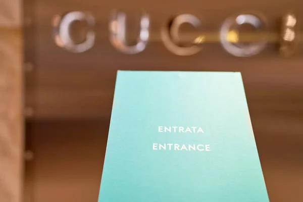 Sinal de entrada em frente a Gucci boutique exterior sinal no fundo. Distrito de moda em Milão. Milão, Itália - 15.12.2020 — Fotografia de Stock