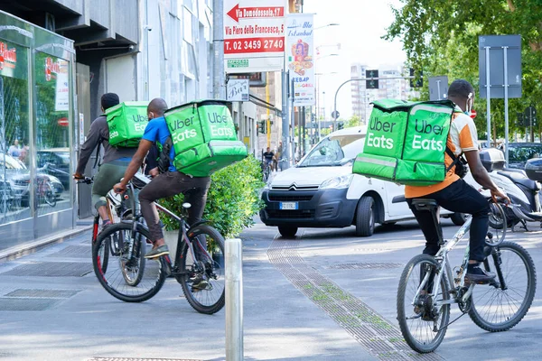 Entrega de hombres con mochila en bicicleta en la calle. Mensajero entregando comida durante la pandemia de coronavirus. Milán, Italia - 16 de junio de 2020 — Foto de Stock