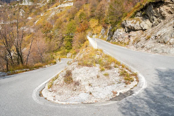 Gefahrenkurve auf Serpentinen-Bergstraße, malerische Alpen-Herbstlandschaft. Lombardei, Italien. — Stockfoto