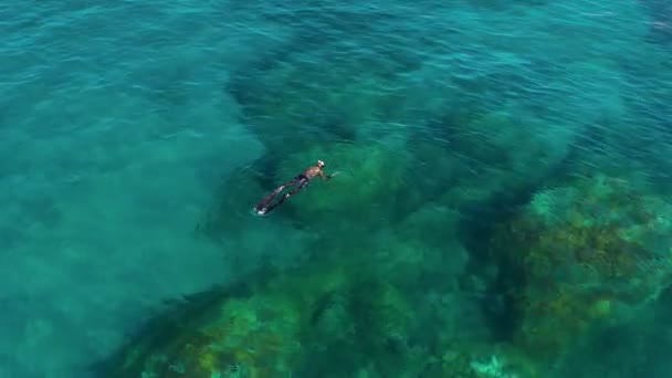 Albisola, Italy - June 13, 2021: Diver diving near coast of ligurian sea in transparent shallow turquoise water. Aerial view above from drone. Ligurian coast, province of Savona — Stock Video