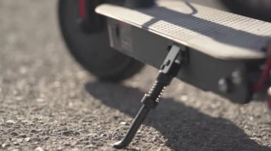 Kadın şehirde elektrikli scooter ya da e-scooter 'a binmeye başlıyor. Elektrikli taşıma konsepti. Milan, İtalya - 4 Nisan 2021. 
