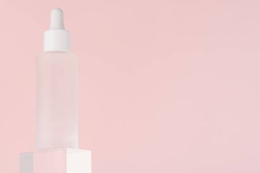 Beyaz şişede kozmetik sıvısı modeli. Hyaluronik asit yağı, şeffaf akrilik küp blokta kolajen ve peptid içeren serum. Paketlemeyi düzenle