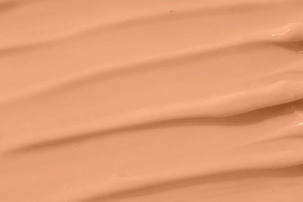 Cosmetic tonal moisturizer, bb cream swatch sample. Beige nude liquid foundation texture, concealer smear smudge drop. Make up base, cream textured background.