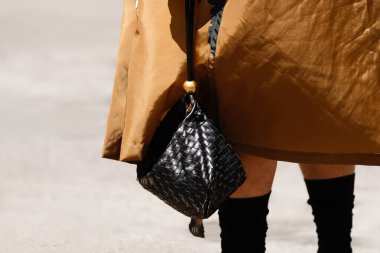 Milan, İtalya - 17 Haziran 2023: kadın Bottega Veneta siyah çanta giyiyor. Moda kıyafetleri, sokak tarzı..