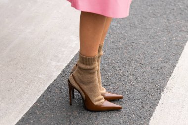 Paris, Fransa - 11 Mart 2025: Paris, Fransa - 11 Mart 2025: Kahverengi Saint Laurent topukluları yaya geçidinde bej çoraplarla giyilir. Sokak tarzı kıyafet ayrıntıları.