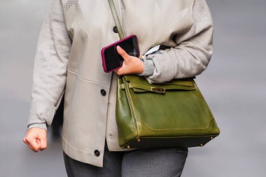 Paris, Fransa - 4 Ekim 2025: Kadın Hermes Kelly zeytin rengi omuz çantası, sokak tarzı ve modern aksesuar giyer