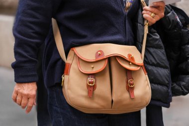 Paris, Fransa - 4 Ekim 2025: Kadın Brady Ariel Alabalık omuz çantası giyiyor, kahverengi deri kayış, sokak tarzı aksesuar modası