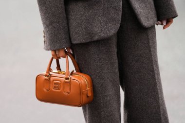 Paris, Fransa - 6 Ekim 2025: Kadın kahverengi Arcadie mini deri çanta giyiyor. Moda kıyafet çantası detayı, sokak tarzı aksesuar.