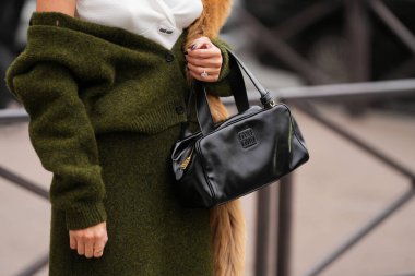 Paris, Fransa - 6 Ekim 2025: Kadın Miu Miu siyah omuz çantası giyiyor. Moda kıyafet çantası detayı, sokak tarzı aksesuar.