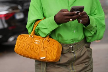 Paris, Fransa - 6 Ekim 2025: Kadın Miu Miu Arcadie Matelasse kahverengi omuz çantası giyiyor. Moda kıyafet çantası detayı, sokak tarzı aksesuar.