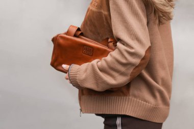 Paris, Fransa - 6 Ekim 2025: Kadın Miu Miu kahverengi omuz çantası giyiyor. Moda kıyafet çantası detayı, sokak tarzı aksesuar.