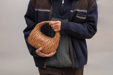 Paris, Fransa - 6 Ekim 2025: Kadın Miu Miu Wander 'ın omuz çantasını tutuyor. Moda kıyafet çantası detayı, sokak tarzı aksesuar.