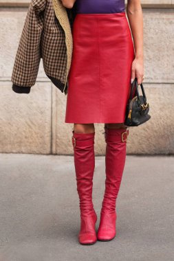 Paris, Fransa - 6 Ekim 2025: Kadınlar Miu Miu kırmızı diz boyu çizme giyerler. Moda kıyafetleri ayakkabılar, sokak tarzı aksesuar..