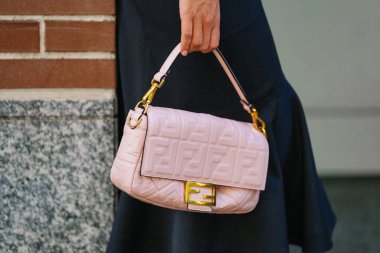 Milan, İtalya - 24 Eylül 2025: Kadın Fendi Baguette pembe çanta giyiyor. Moda kıyafeti çanta ayrıntıları, sokak tarzı aksesuar.