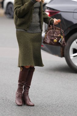 Paris, Fransa - 6 Ekim 2025: Kadın Miu Miu Aventure kahverengi omuz çantası giyiyor. Moda kıyafet çantası detayı, sokak tarzı aksesuar.