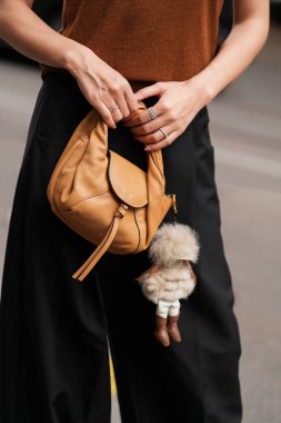 Milan, İtalya - 24 Eylül 2025: Kadın Fendi Spy marka küçük bej bir çanta takıyor. Moda kıyafeti çanta ayrıntıları, sokak tarzı aksesuar.