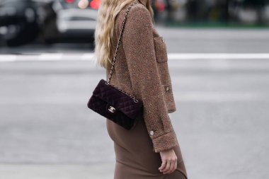 Paris, France - October, 06, 2025: woman wears Chanel velvet dark brown classic bag. Fashion outfit handbag details, street style look accessory