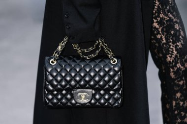 Paris, Fransa - Ekim, 06, 2025: Kadınlar Chanel klasik flep jumbo çanta giyer. Moda kıyafeti çanta ayrıntıları, sokak tarzı aksesuar.