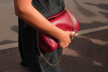 Milan, İtalya - 25 Eylül 2025: Kadın kırmızı Prada Tumulte nappa deri çanta giyiyor. Moda kıyafeti çanta ayrıntıları, sokak tarzı aksesuar.