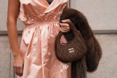 Paris, Fransa - 6 Ekim 2025: Kadınlar toplanmış desenli Miu Miu Wander kahverengi çanta giyerler. Moda kıyafet çantası detayı, sokak tarzı aksesuar.