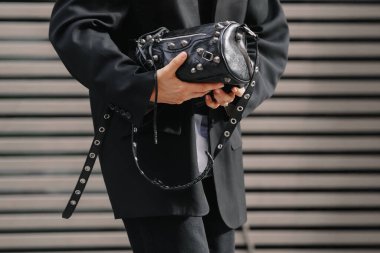 Paris, Fransa - Ekim 06, 2025: Kadın Balenciaga Le Cagole silindir çanta giyiyor. Moda kıyafeti çanta ayrıntıları, sokak tarzı aksesuar.