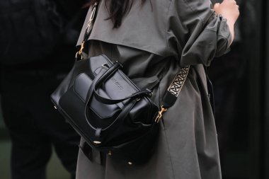 Paris, Fransa - Ekim 06, 2025: Kadın ABD ve Iris 'in çapraz gövdeleri siyah serap çanta giyer. Moda kıyafeti çanta ayrıntıları, sokak tarzı aksesuar.