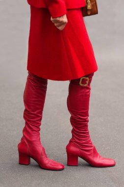 Paris, Fransa - 6 Ekim 2025: Kadınlar Miu Miu kırmızı diz boyu çizme giyerler. Moda kıyafetleri ayakkabılar, sokak tarzı aksesuar..