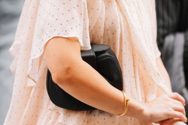 Paris, Fransa - Ekim 06, 2025: Kadın Gabriela Hearst yumuşak demi debriyaj siyah deri çanta giyiyor. Moda kıyafeti çanta ayrıntıları, sokak tarzı aksesuar.