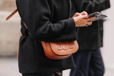 Paris, Fransa - Ekim 06, 2025: Kadın Celine Folco Cuir Triomphe çantası takıyor. Moda kıyafeti çanta ayrıntıları, sokak tarzı aksesuar.