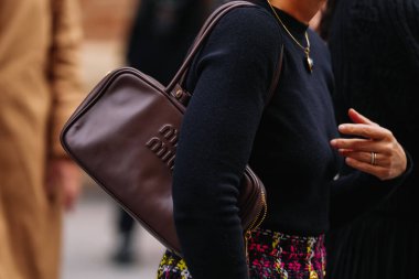 Paris, Fransa - 6 Ekim 2025: Kadın Miu Miu Arcadie kahverengi omuz çantası giyiyor. Moda kıyafet çantası detayı, sokak tarzı aksesuar.