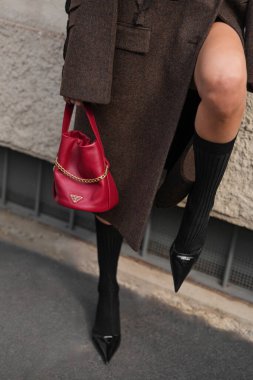 Milan, İtalya - 25 Eylül 2025: Kadınlar Prada kırmızı Petite Sac Noir Mini Nappa deri kova çanta giyerler. Moda kıyafeti çanta ayrıntıları, sokak tarzı aksesuar.