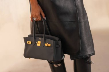 Paris, Fransa - 4 Ekim 2025: Kadın Hermes Birkin siyah çanta giyiyor. Moda kıyafeti çanta ayrıntıları, sokak tarzı aksesuarlar.