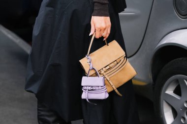 Milan, İtalya - 25 Eylül 2025: Kadınlar Moschino Tie Me çantası takıyor. Moda kıyafeti çanta ayrıntıları, sokak tarzı aksesuar.