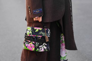 Milan, İtalya - 25 Eylül 2025: Kadınlar Moschino Tie Me çantası takıyor. Moda kıyafeti çanta ayrıntıları, sokak tarzı aksesuar.