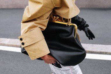 Milan, İtalya - 25 Eylül 2025: Kadın, Koç 'un kocaman bir öpücük çerçeveli çanta takıyor. Moda kıyafeti çanta ayrıntıları, sokak tarzı aksesuar.