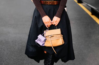 Milan, İtalya - 25 Eylül 2025: Kadınlar Moschino Tie Me çantası takıyor. Moda kıyafeti çanta ayrıntıları, sokak tarzı aksesuar.