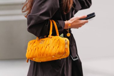 Paris, Fransa - Ekim 06, 2025: Kadın Miu Miu Arcadie Matelasse kahverengi omuz çantası giyiyor. Moda kıyafet çantası detayı, sokak tarzı aksesuar.